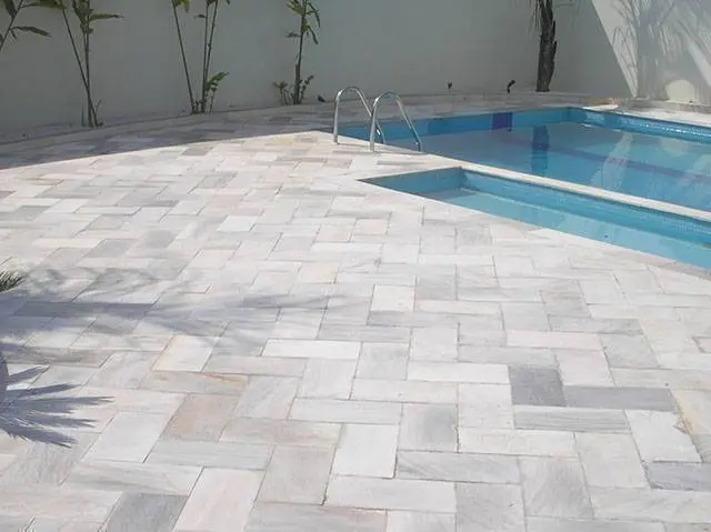 Aplicação de pedras naturais ao redor de uma piscina